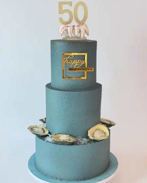 Three-tier 50th birthday cake with gold number topper
