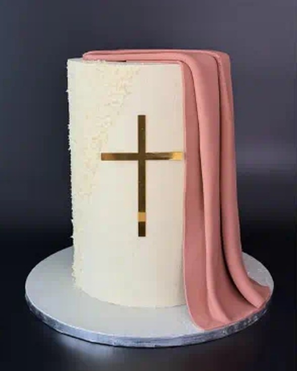 Ivory baptism cake with gold cross and draped blush fondant